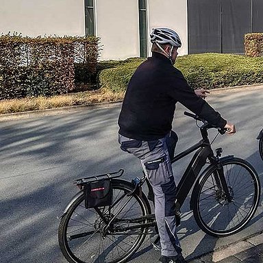 Personen auf Fahrrädern vor dem Hettich-Gebäude