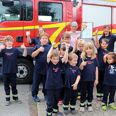 Kinder und Erwachsene vor einem Feuerwehrfahrzeug zum Thema Hettich Ehrenamt